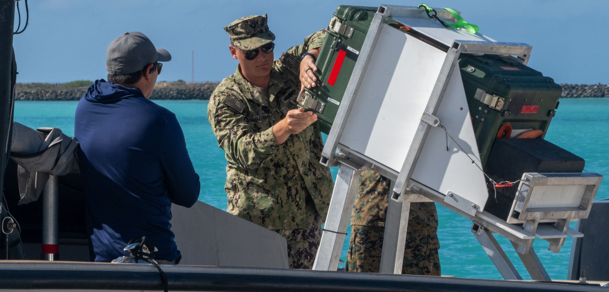Naval Postgraduate School student U.S. Navy Lt. Evan Humphreys prepares cargo for transit via an unmanned surface vessel during RIMPAC 2026, July 7.