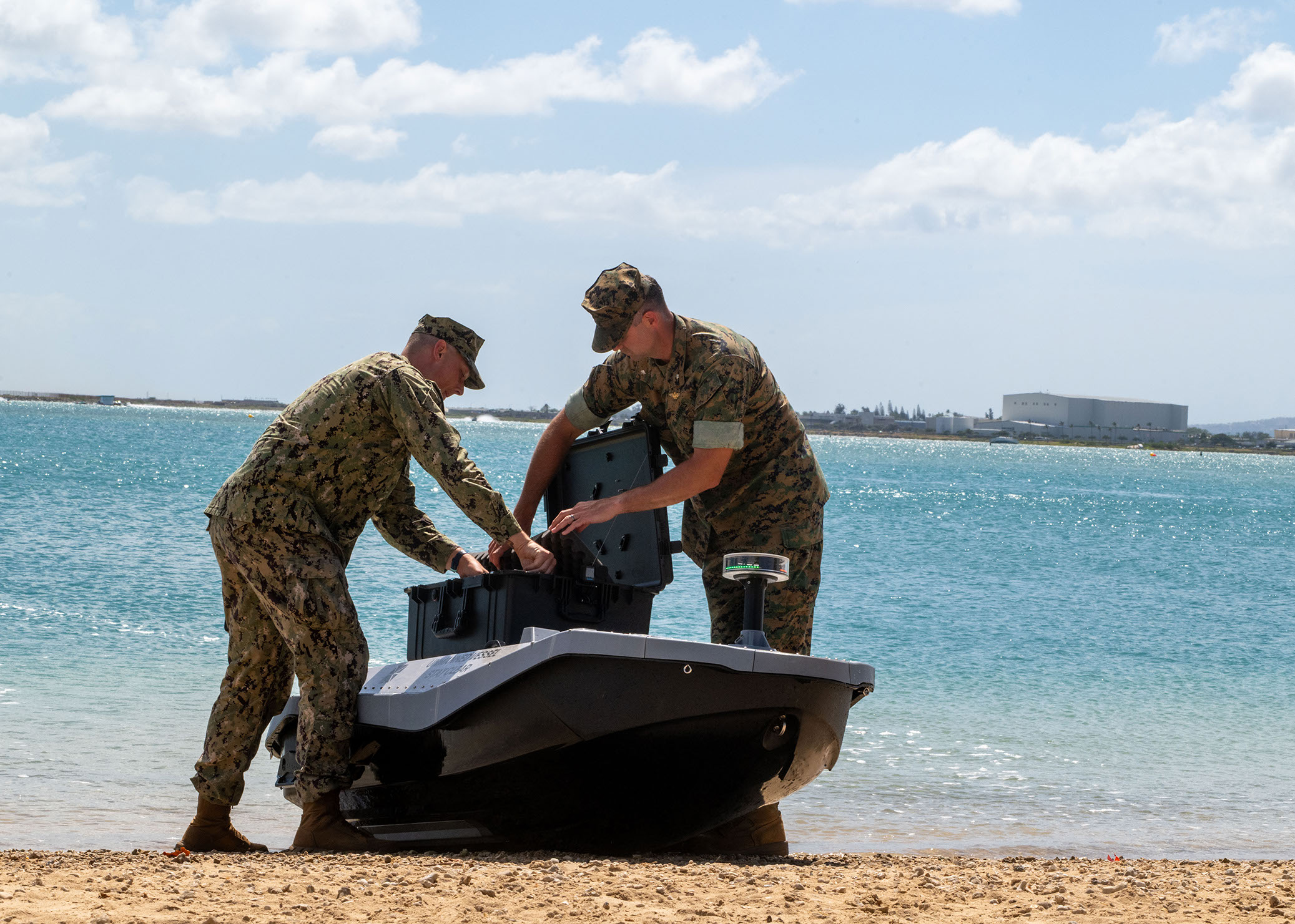 NPS student US Navy Lt. Evan Humphreys and Marine Corps Lt. Col. Michael Radigan load cargo onto a digitally screwed surface vessel at the Honolulu Harbor Public Boat Ramp in Honolulu, Hawaii, July 7, 2026.